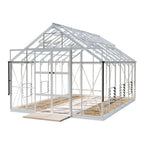 A white-framed Rhino Greenhouse with transparent panels stands on a flat, paved surface, featuring roof vents and sliding double doors for ventilation. It has a spacious interior with visible pathways.