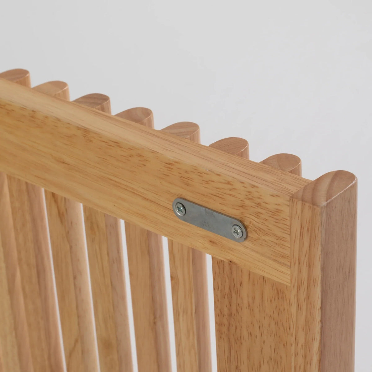 Wooden chair back with metal bracket on a light gray background